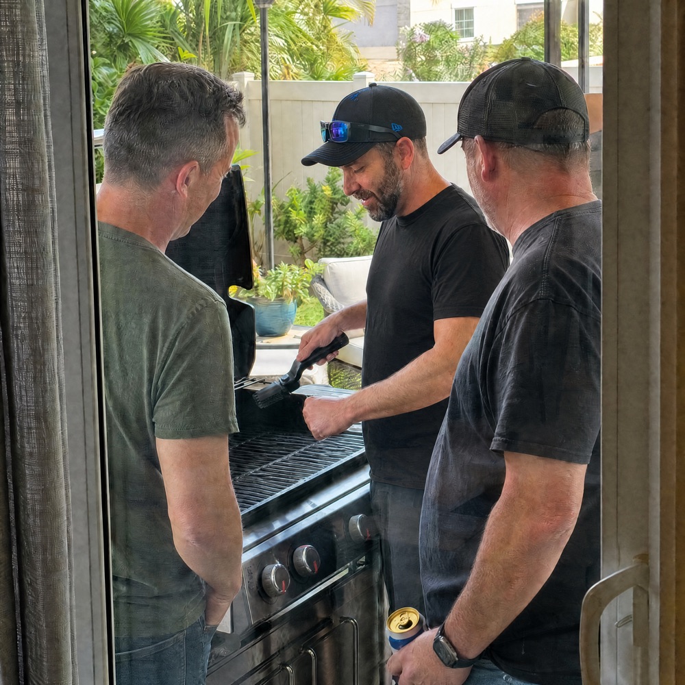 Marlene's dad smiling while grilling with his buddies